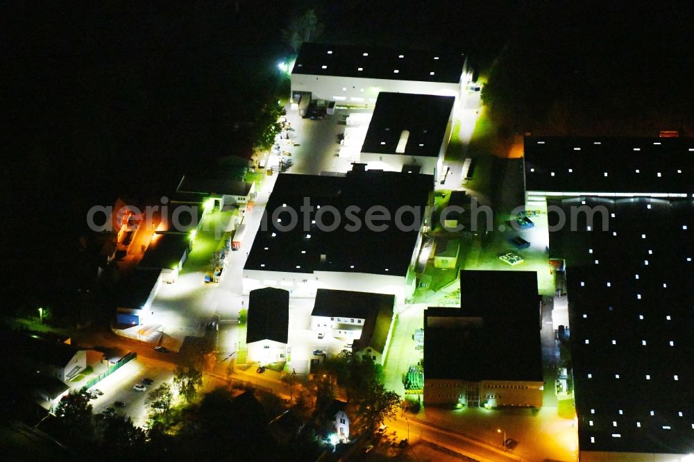 Aerial image at night Radeburg - Night lighting building and production halls on the premises of Mitras GmbH on Bahnhofstrasse in Radeburg in the state Saxony, Germany