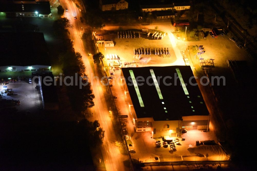 Neubrandenburg at night from the bird perspective: Night lighting Building and production halls on the premises of Praefa GmbH NL Blaehton Fertigteilwerk on Ihlenfelder Strasse in Neubrandenburg in the state Mecklenburg - Western Pomerania, Germany