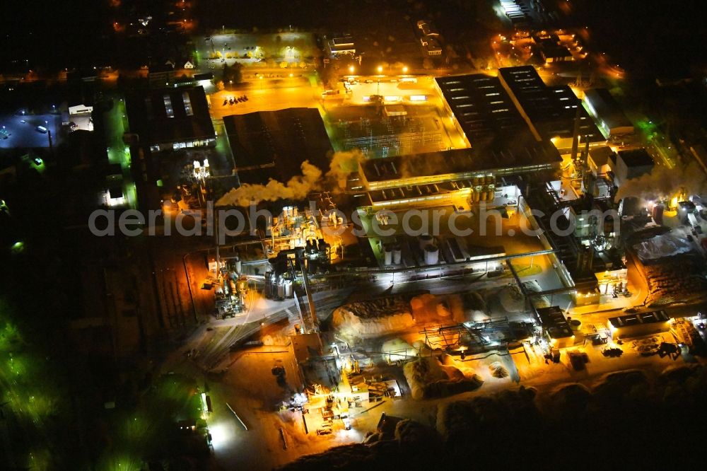 Beeskow at night from the bird perspective: Night lighting Building and production halls on the premises of Sonae Arauco Deutschland GmbH in Beeskow in the state Brandenburg, Germany