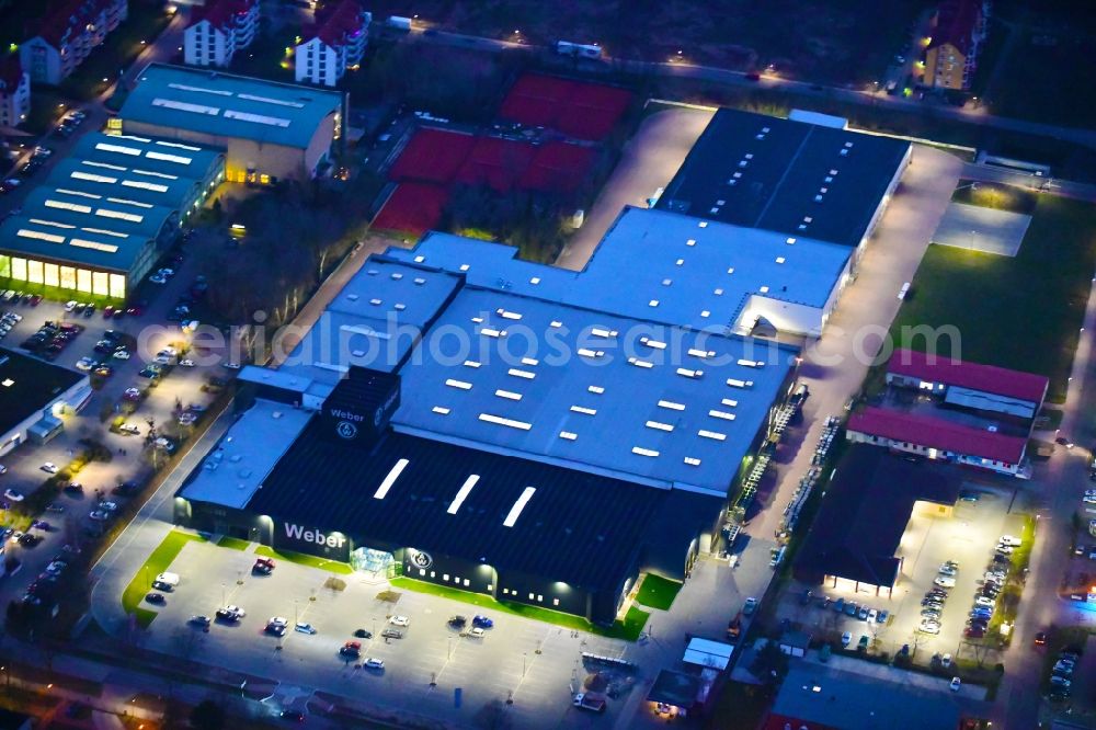 Aerial image at night Bernau - Night lighting building and production halls on the premises of Weber Automotive GmbH in Bernau in the state Brandenburg, Germany