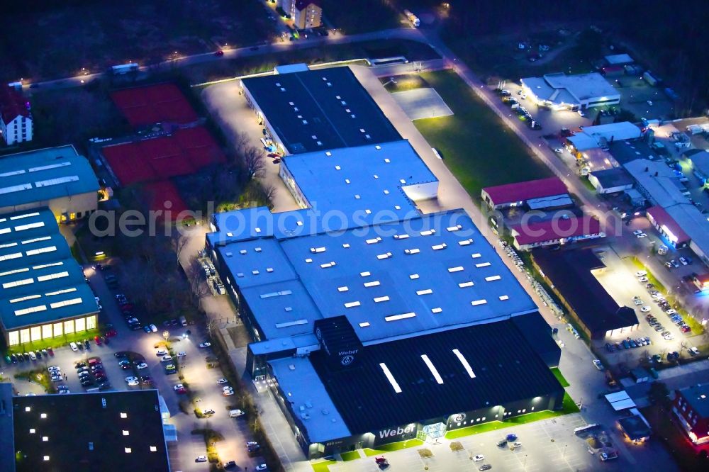 Bernau at night from the bird perspective: Night lighting building and production halls on the premises of Weber Automotive GmbH in Bernau in the state Brandenburg, Germany