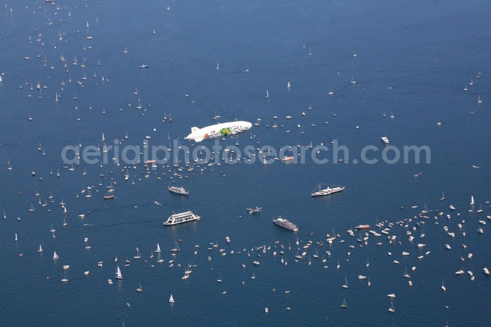 Friedrichshafen from above - Between Romanshorn in Switzerland and Friedrichshafen in Germany 2500 ships form a bridge of boats to commemorate the help of the Swiss people for the German post-war children 60 years ago. In the middle of the lake, a large Swiss cross was formed by large vessels. In the middle of the cross the historic flying boat Do 24