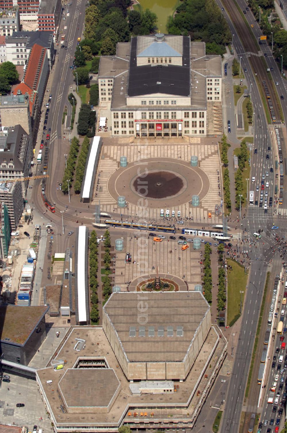 Aerial photograph Leipzig - Blick auf den Augustusplatz, den größten Platz der Stadt Leipzig. Vor der Zerstörung fast sämtlicher Bauten des Augustusplatzes im 2. Weltkrieg war dieser als einer der schönsten deutschen Plätze bekannt. Durch die Zerstörung im Zweiten Weltkrieg und umfassender städtebauliche Maßnahmen während der DDR hat der Augustusplatz sein historisches Bild verloren. Der Augustusplatz wird dominiert vom Opernhaus am Nordrand (oben im Bild), dem Neuen Gewandhaus am Südrand und dem Hauptgebäude der Universität samt City-Hochhaus Leipzig am der Innenstadt zugewandten Westrand (nicht im Bild). Das Neue Gewandhaus ist Heimstätte des Gewandhausorchesters Leipzig. Den Platz unmittelbar vor dem Neuen Gewandhaus ziert der Mendebrunnen, der einzig erhalten gebliebene Teil des ursprünglichen Platzensembles. Der Baukran links im Bild gehört zur Baustelle des Paulinums, einem vom Architekten Erick van Egeraat gestalteten Erweiterungsbau der Universität, der an die Universitätskirche St. Pauli erinnern soll, die 1968 gesprengt wurde.