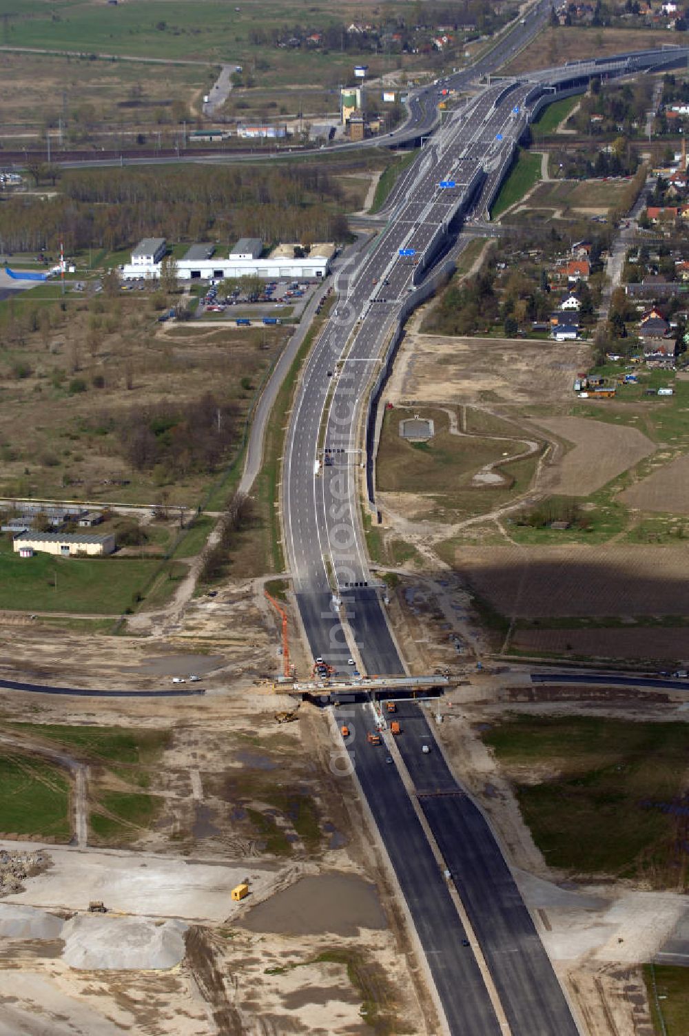 Aerial photograph Schönefeld - Blick auf den Bereich der Stadtautobahn / Zubringer A113n als südöstliches Tor zur Hauptstadt kurz vor der Verkehrsfreigabe. Unter Berücksichtigung des Flughafens Berlin Brandenburg International wurde eine Verkehrskonzeption für den Ausbau des Straßennetzes im Raum Berlin-Schönefeld erarbeitet, die zwei Stufen umfasste. Die erste Stufe sah den vierstreifigen Ausbau der Bundesstraßen B 96a und B 179 mit der Anbindung des Flughafens über zwei Knotenpunkte vor. Inhalt der zweiten Stufe war der Anschluß der Bundesautobahn A 113 neu an die B 96a und B 179. SCHÜßLER Plan Ingenieurgesellschaft, BATEG, EUROVIA, BERGER