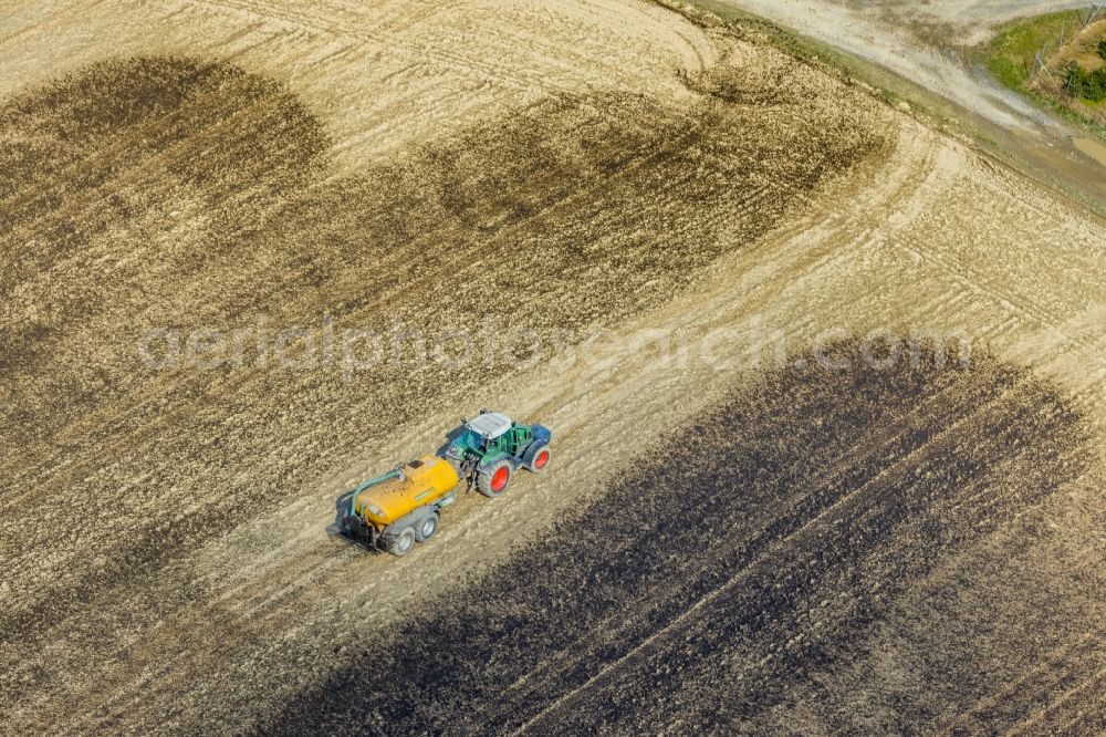 Aerial photograph Enkdorf - Spraying manure as fertilizer with tractor and tank trailer on agricultural fields in Enkdorf in the state North Rhine-Westphalia, Germany