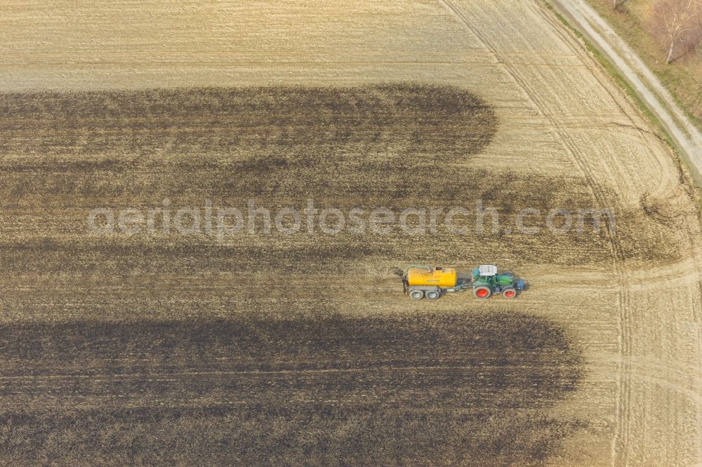 Aerial image Enkdorf - Spraying manure as fertilizer with tractor and tank trailer on agricultural fields in Enkdorf in the state North Rhine-Westphalia, Germany