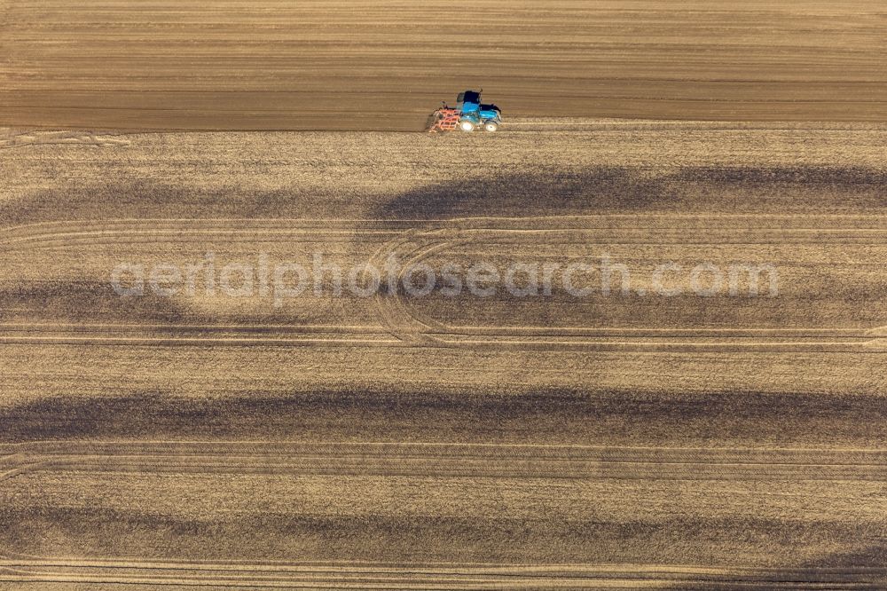 Friedrichsfeld from the bird's eye view: Spraying manure as fertilizer with tractor and tank trailer on agricultural fields in Friedrichsfeld in the state North Rhine-Westphalia, Germany