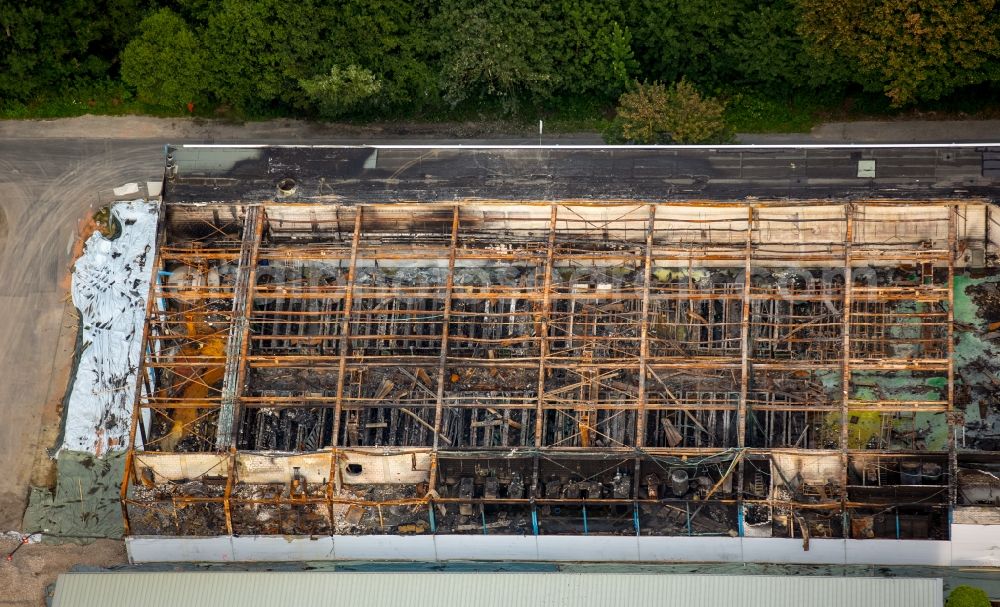 Warstein from the bird's eye view: Burnt down building of the Al Gramm company in the commerce area of Waersteral in Warstein in the state of North Rhine-Westphalia. The burnt building is located near a forest