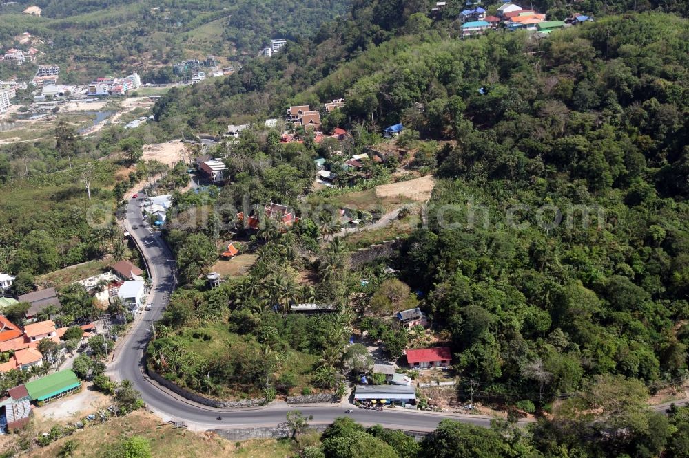 Aerial image Patong - Outskirts of the city of Patong on Phuket Island in Thailand with traditional houses with palm trees