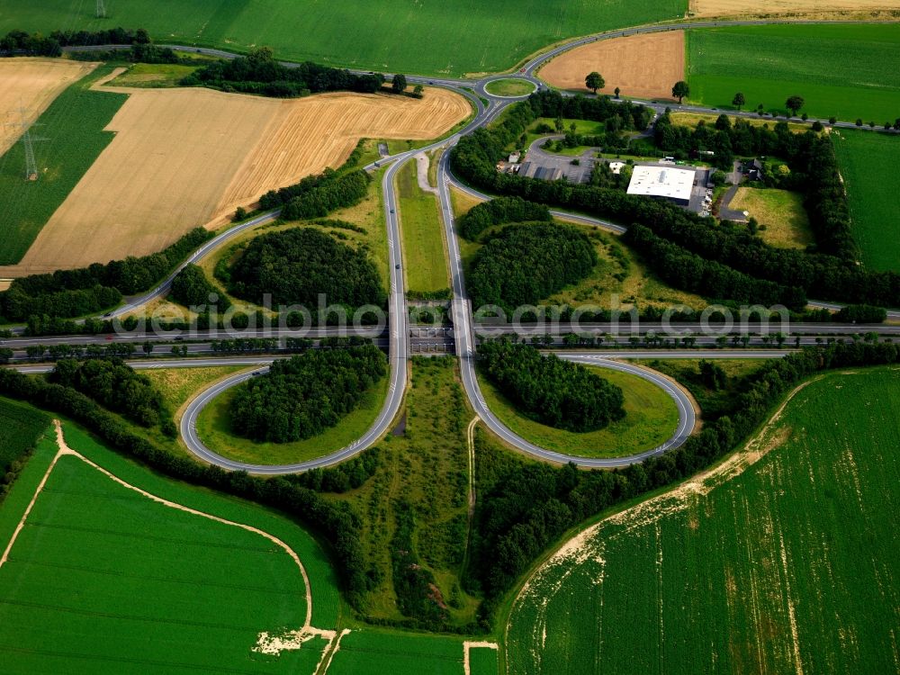 Aerial photograph Jülich - Motorway intersection Juelich-West in Juelich in the state of North Rhine-Westphalia. The interchange in a half shamrock shape connects the federal motorway A44 with the highway 7 and is located in the West of the town, surrounded by fields and forest spaces