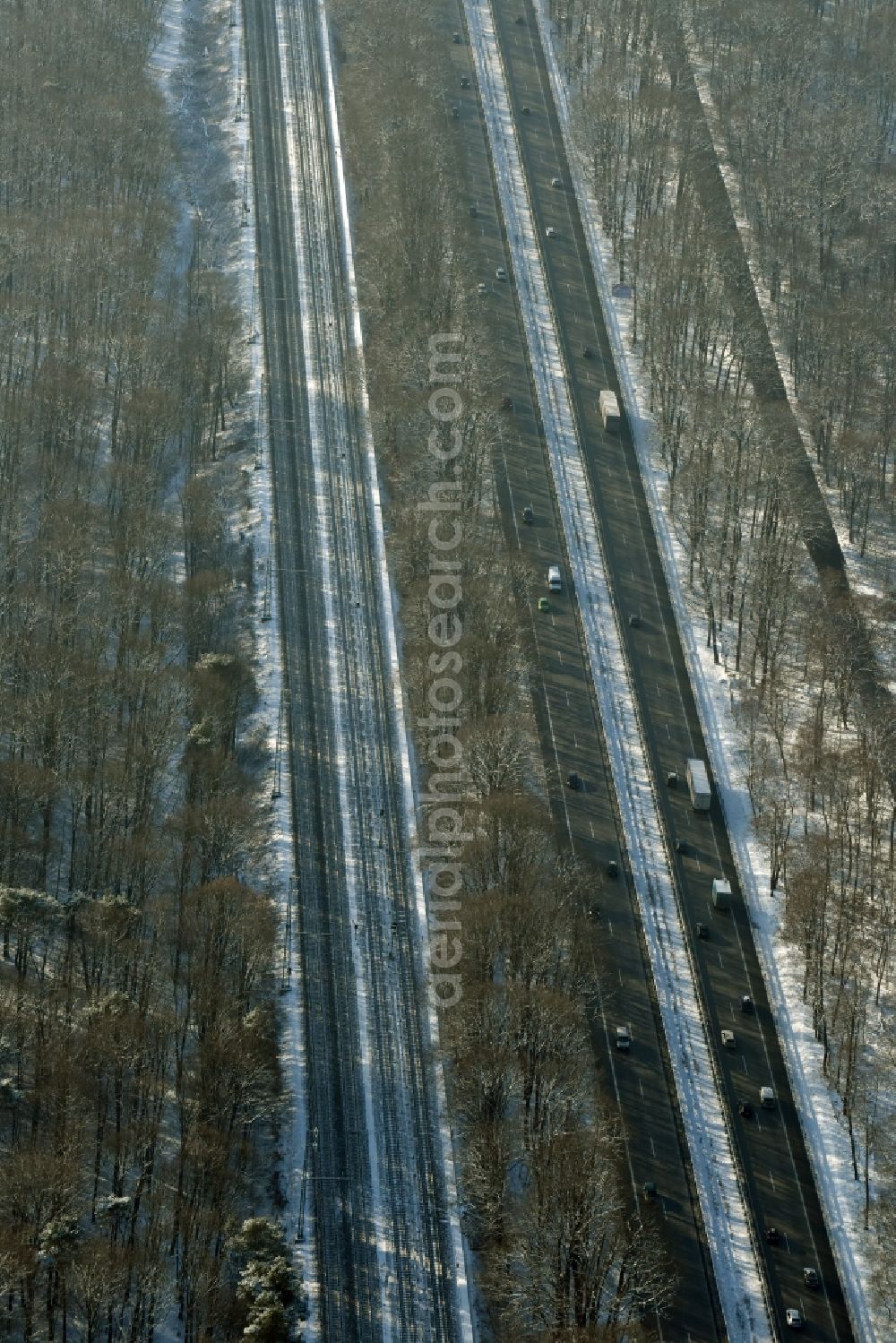 Berlin from above - Snow covered course of the federal motorway A115 in the Southern Grunewald forest area in the district of Steglitz-Zehlendorf in Berlin in Germany. Railway tracks are running parallel to the road