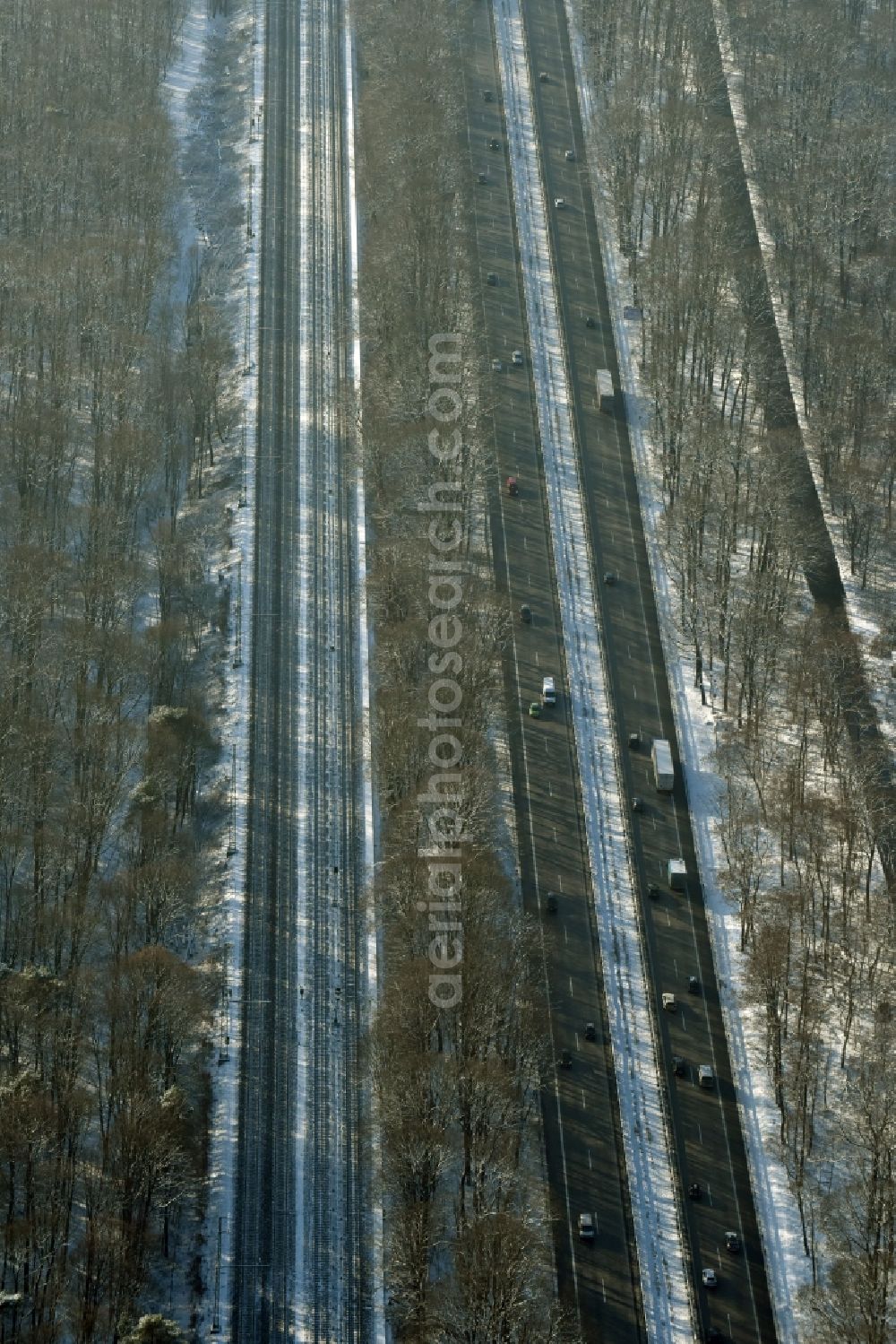 Aerial image Berlin - Snow covered course of the federal motorway A115 in the Southern Grunewald forest area in the district of Steglitz-Zehlendorf in Berlin in Germany. Railway tracks are running parallel to the road