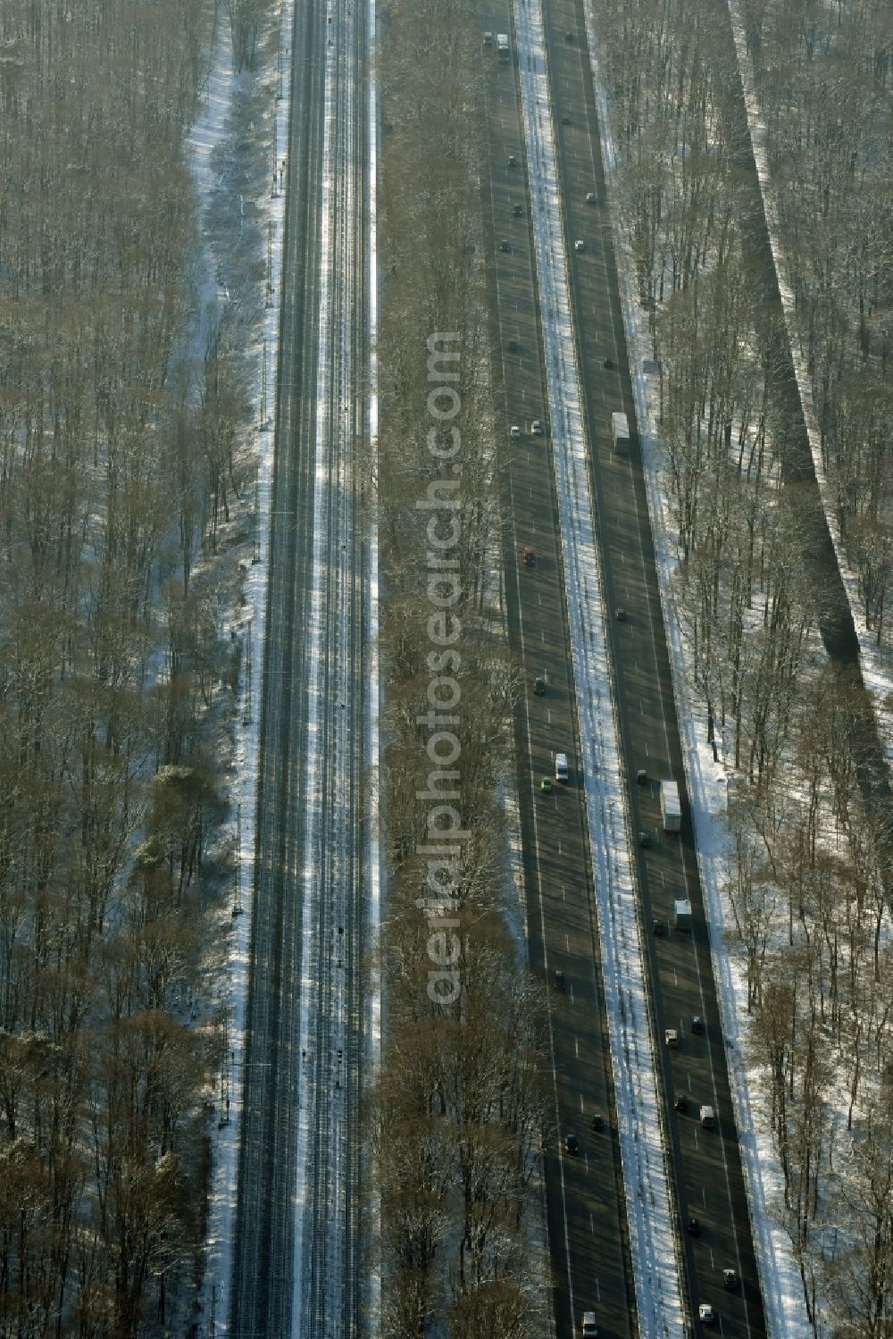 Aerial photograph Berlin - Snow covered course of the federal motorway A115 in the Southern Grunewald forest area in the district of Steglitz-Zehlendorf in Berlin in Germany. Railway tracks are running parallel to the road