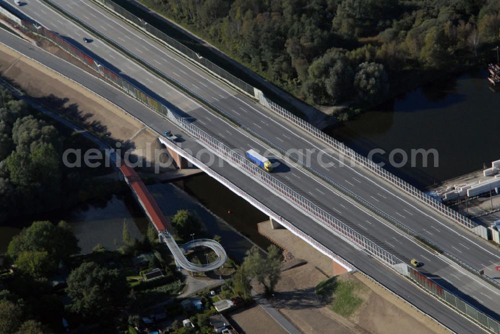 Niederlehme from above - Blick auf die Autobahnbrücke der A10 bei Niederlehme. Die Brücke führt die Bundesautobahn Berliner Ring über den Fluss Dahme in Brandenburg nahe der Stadt Niederlehme und Königs Wusterhausen. Direkt an der Überführung befindet sich ein Kalksandsteinwerk und ein Wasserturm, Wahrzeichen von Niederlehme.