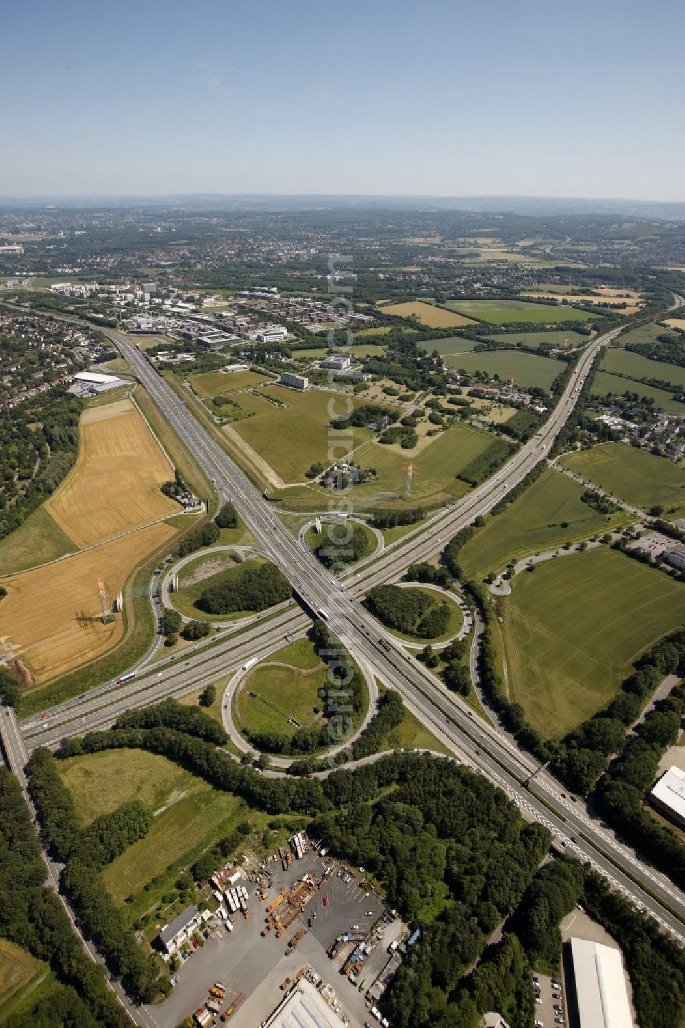 Aerial photograph Dortmund - View at the motorway intersection Dortmund-West in Dortmund in North Rhine-Westphalia. It connects the Highways A 40 and A 45 with each other. The cross has a cloverleaf shape and is located right on Indupark. Responsible is the state owned Strassen.NRW