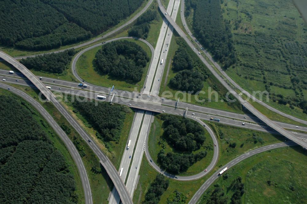 Schönefeld from the bird's eye view: Blick auf das Autobahnkreuz Schönefeld. Das Schönefelder Kreuz (umgangssprachlich auch Kreuz Schönefeld) ist ein Autobahnkreuz am südlichen Berliner Ring (A 10), der nach Süden die A 13 Dresden und nach Norden die A 113 Berlin anbindet. Das Kreuz wurde ursprünglich in der verbreiteten Kleeblattform errichtet, wobei drei sehr enge Kreisel (Tempo: 20 bis 40 km/h) gesetzt wurden, bis zur Wende fehlte sogar eine Tangente (Durchfahren von drei Kreiseln notwendig). Lediglich der Kreisel im nordwestlichen Quadranten des Autobahnkreuzes wurde überdimensioniert - in Relation zum gesamten Autobahnkreuz - errichtet. Der Umbau des Schönefelder Kreuzes in den 1990ern brachte eine Mischform hervor, die in Richtung eines Malteserkreuzes geht, der Wechsel Nord nach Ost und Süd nach West hat jedoch weiterhin enge Kreisel.