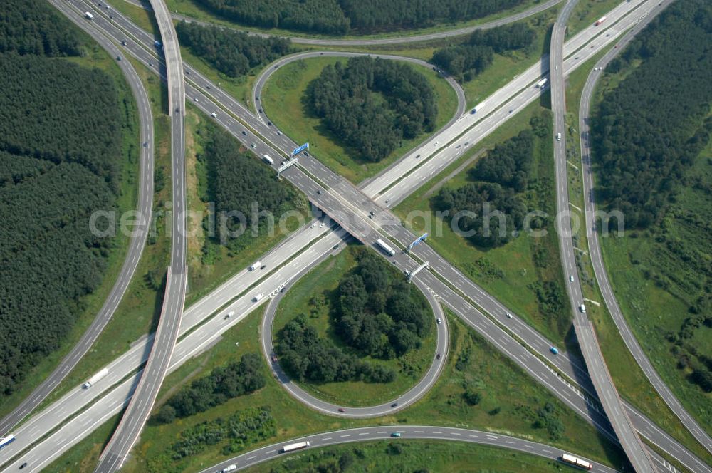 Aerial image Schönefeld - Blick auf das Autobahnkreuz Schönefeld. Das Schönefelder Kreuz (umgangssprachlich auch Kreuz Schönefeld) ist ein Autobahnkreuz am südlichen Berliner Ring (A 10), der nach Süden die A 13 Dresden und nach Norden die A 113 Berlin anbindet. Das Kreuz wurde ursprünglich in der verbreiteten Kleeblattform errichtet, wobei drei sehr enge Kreisel (Tempo: 20 bis 40 km/h) gesetzt wurden, bis zur Wende fehlte sogar eine Tangente (Durchfahren von drei Kreiseln notwendig). Lediglich der Kreisel im nordwestlichen Quadranten des Autobahnkreuzes wurde überdimensioniert - in Relation zum gesamten Autobahnkreuz - errichtet. Der Umbau des Schönefelder Kreuzes in den 1990ern brachte eine Mischform hervor, die in Richtung eines Malteserkreuzes geht, der Wechsel Nord nach Ost und Süd nach West hat jedoch weiterhin enge Kreisel.