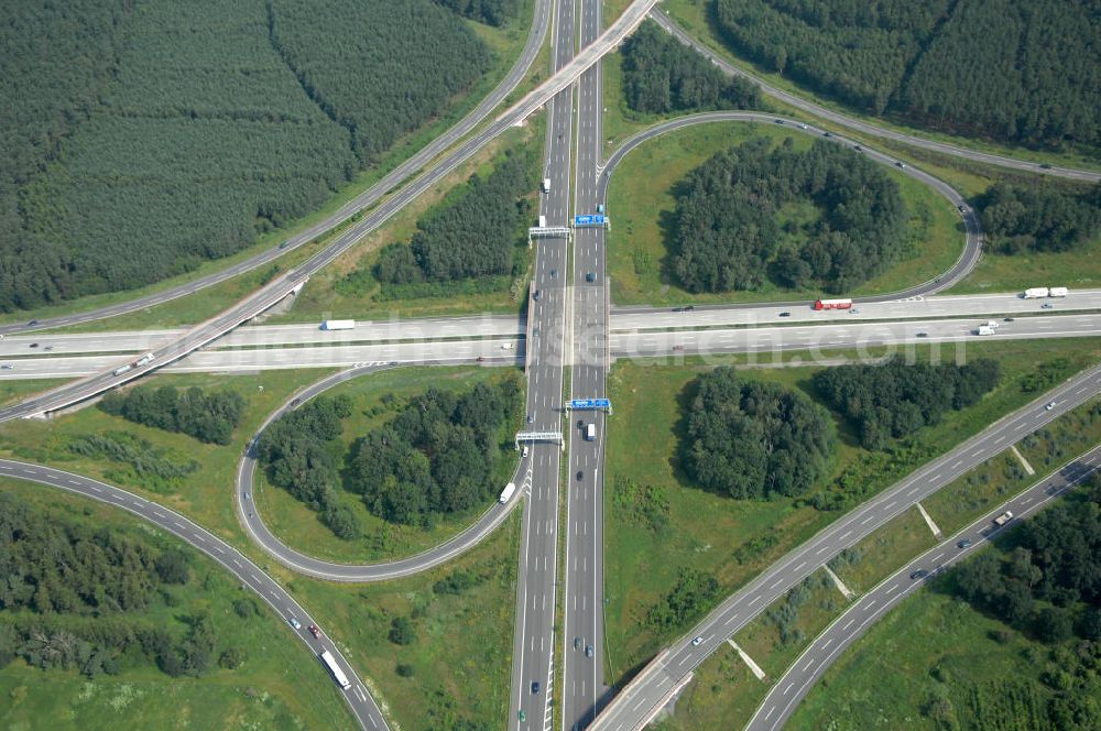 Aerial photograph Schönefeld - Blick auf das Autobahnkreuz Schönefeld. Das Schönefelder Kreuz (umgangssprachlich auch Kreuz Schönefeld) ist ein Autobahnkreuz am südlichen Berliner Ring (A 10), der nach Süden die A 13 Dresden und nach Norden die A 113 Berlin anbindet. Das Kreuz wurde ursprünglich in der verbreiteten Kleeblattform errichtet, wobei drei sehr enge Kreisel (Tempo: 20 bis 40 km/h) gesetzt wurden, bis zur Wende fehlte sogar eine Tangente (Durchfahren von drei Kreiseln notwendig). Lediglich der Kreisel im nordwestlichen Quadranten des Autobahnkreuzes wurde überdimensioniert - in Relation zum gesamten Autobahnkreuz - errichtet. Der Umbau des Schönefelder Kreuzes in den 1990ern brachte eine Mischform hervor, die in Richtung eines Malteserkreuzes geht, der Wechsel Nord nach Ost und Süd nach West hat jedoch weiterhin enge Kreisel.