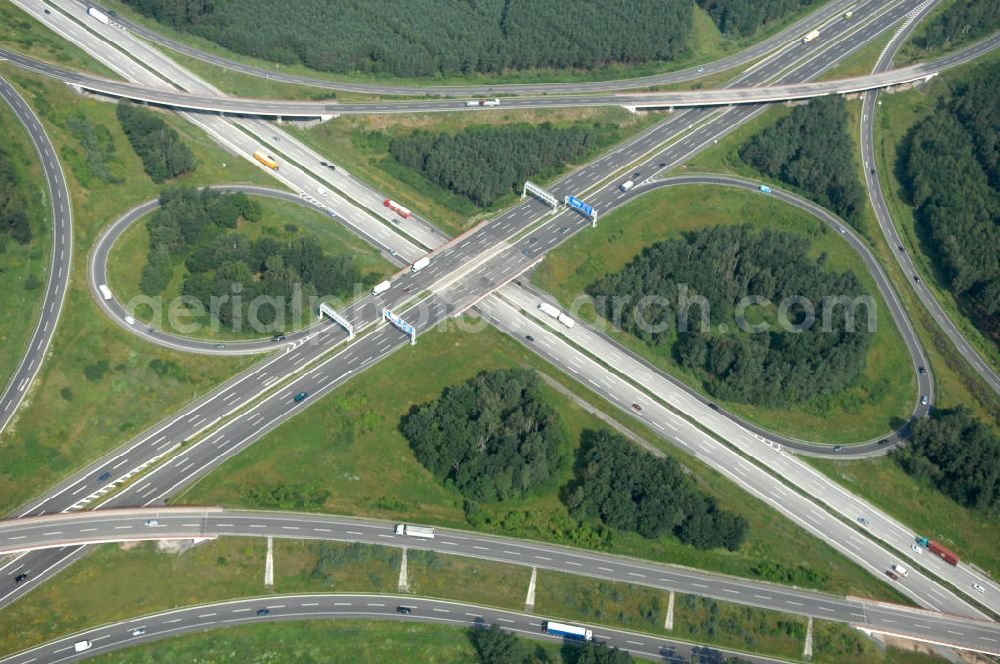 Schönefeld from the bird's eye view: Blick auf das Autobahnkreuz Schönefeld. Das Schönefelder Kreuz (umgangssprachlich auch Kreuz Schönefeld) ist ein Autobahnkreuz am südlichen Berliner Ring (A 10), der nach Süden die A 13 Dresden und nach Norden die A 113 Berlin anbindet. Das Kreuz wurde ursprünglich in der verbreiteten Kleeblattform errichtet, wobei drei sehr enge Kreisel (Tempo: 20 bis 40 km/h) gesetzt wurden, bis zur Wende fehlte sogar eine Tangente (Durchfahren von drei Kreiseln notwendig). Lediglich der Kreisel im nordwestlichen Quadranten des Autobahnkreuzes wurde überdimensioniert - in Relation zum gesamten Autobahnkreuz - errichtet. Der Umbau des Schönefelder Kreuzes in den 1990ern brachte eine Mischform hervor, die in Richtung eines Malteserkreuzes geht, der Wechsel Nord nach Ost und Süd nach West hat jedoch weiterhin enge Kreisel.