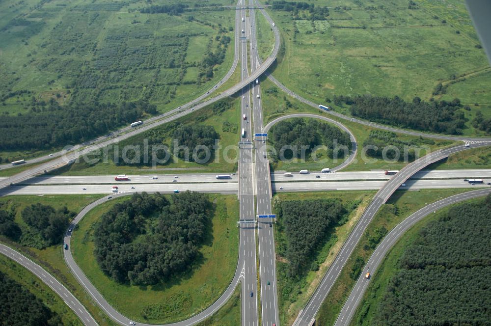 Aerial image Schönefeld - Blick auf das Autobahnkreuz Schönefeld. Das Schönefelder Kreuz (umgangssprachlich auch Kreuz Schönefeld) ist ein Autobahnkreuz am südlichen Berliner Ring (A 10), der nach Süden die A 13 Dresden und nach Norden die A 113 Berlin anbindet. Das Kreuz wurde ursprünglich in der verbreiteten Kleeblattform errichtet, wobei drei sehr enge Kreisel (Tempo: 20 bis 40 km/h) gesetzt wurden, bis zur Wende fehlte sogar eine Tangente (Durchfahren von drei Kreiseln notwendig). Lediglich der Kreisel im nordwestlichen Quadranten des Autobahnkreuzes wurde überdimensioniert - in Relation zum gesamten Autobahnkreuz - errichtet. Der Umbau des Schönefelder Kreuzes in den 1990ern brachte eine Mischform hervor, die in Richtung eines Malteserkreuzes geht, der Wechsel Nord nach Ost und Süd nach West hat jedoch weiterhin enge Kreisel.