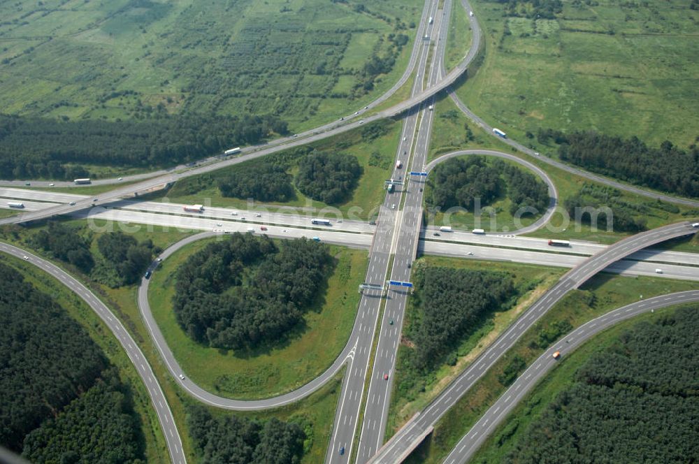 Aerial photograph Schönefeld - Blick auf das Autobahnkreuz Schönefeld. Das Schönefelder Kreuz (umgangssprachlich auch Kreuz Schönefeld) ist ein Autobahnkreuz am südlichen Berliner Ring (A 10), der nach Süden die A 13 Dresden und nach Norden die A 113 Berlin anbindet. Das Kreuz wurde ursprünglich in der verbreiteten Kleeblattform errichtet, wobei drei sehr enge Kreisel (Tempo: 20 bis 40 km/h) gesetzt wurden, bis zur Wende fehlte sogar eine Tangente (Durchfahren von drei Kreiseln notwendig). Lediglich der Kreisel im nordwestlichen Quadranten des Autobahnkreuzes wurde überdimensioniert - in Relation zum gesamten Autobahnkreuz - errichtet. Der Umbau des Schönefelder Kreuzes in den 1990ern brachte eine Mischform hervor, die in Richtung eines Malteserkreuzes geht, der Wechsel Nord nach Ost und Süd nach West hat jedoch weiterhin enge Kreisel.