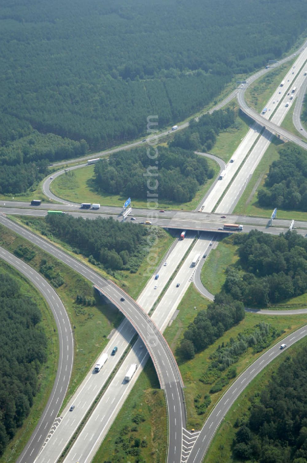 Schönefeld from the bird's eye view: Blick auf das Autobahnkreuz Schönefeld. Das Schönefelder Kreuz (umgangssprachlich auch Kreuz Schönefeld) ist ein Autobahnkreuz am südlichen Berliner Ring (A 10), der nach Süden die A 13 Dresden und nach Norden die A 113 Berlin anbindet. Das Kreuz wurde ursprünglich in der verbreiteten Kleeblattform errichtet, wobei drei sehr enge Kreisel (Tempo: 20 bis 40 km/h) gesetzt wurden, bis zur Wende fehlte sogar eine Tangente (Durchfahren von drei Kreiseln notwendig). Lediglich der Kreisel im nordwestlichen Quadranten des Autobahnkreuzes wurde überdimensioniert - in Relation zum gesamten Autobahnkreuz - errichtet. Der Umbau des Schönefelder Kreuzes in den 1990ern brachte eine Mischform hervor, die in Richtung eines Malteserkreuzes geht, der Wechsel Nord nach Ost und Süd nach West hat jedoch weiterhin enge Kreisel.