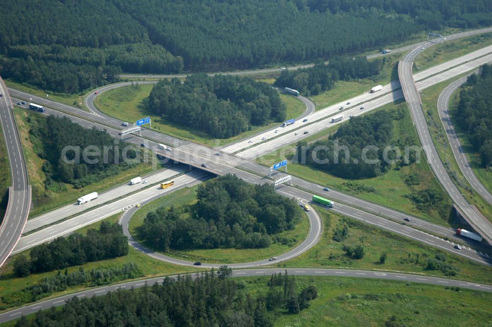 Aerial image Schönefeld - Blick auf das Autobahnkreuz Schönefeld. Das Schönefelder Kreuz (umgangssprachlich auch Kreuz Schönefeld) ist ein Autobahnkreuz am südlichen Berliner Ring (A 10), der nach Süden die A 13 Dresden und nach Norden die A 113 Berlin anbindet. Das Kreuz wurde ursprünglich in der verbreiteten Kleeblattform errichtet, wobei drei sehr enge Kreisel (Tempo: 20 bis 40 km/h) gesetzt wurden, bis zur Wende fehlte sogar eine Tangente (Durchfahren von drei Kreiseln notwendig). Lediglich der Kreisel im nordwestlichen Quadranten des Autobahnkreuzes wurde überdimensioniert - in Relation zum gesamten Autobahnkreuz - errichtet. Der Umbau des Schönefelder Kreuzes in den 1990ern brachte eine Mischform hervor, die in Richtung eines Malteserkreuzes geht, der Wechsel Nord nach Ost und Süd nach West hat jedoch weiterhin enge Kreisel.