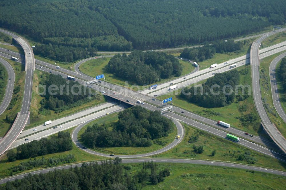 Aerial photograph Schönefeld - Blick auf das Autobahnkreuz Schönefeld. Das Schönefelder Kreuz (umgangssprachlich auch Kreuz Schönefeld) ist ein Autobahnkreuz am südlichen Berliner Ring (A 10), der nach Süden die A 13 Dresden und nach Norden die A 113 Berlin anbindet. Das Kreuz wurde ursprünglich in der verbreiteten Kleeblattform errichtet, wobei drei sehr enge Kreisel (Tempo: 20 bis 40 km/h) gesetzt wurden, bis zur Wende fehlte sogar eine Tangente (Durchfahren von drei Kreiseln notwendig). Lediglich der Kreisel im nordwestlichen Quadranten des Autobahnkreuzes wurde überdimensioniert - in Relation zum gesamten Autobahnkreuz - errichtet. Der Umbau des Schönefelder Kreuzes in den 1990ern brachte eine Mischform hervor, die in Richtung eines Malteserkreuzes geht, der Wechsel Nord nach Ost und Süd nach West hat jedoch weiterhin enge Kreisel.