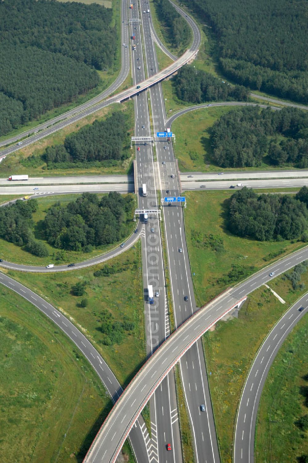 Aerial image Schönefeld - Blick auf das Autobahnkreuz Schönefeld. Das Schönefelder Kreuz (umgangssprachlich auch Kreuz Schönefeld) ist ein Autobahnkreuz am südlichen Berliner Ring (A 10), der nach Süden die A 13 Dresden und nach Norden die A 113 Berlin anbindet. Das Kreuz wurde ursprünglich in der verbreiteten Kleeblattform errichtet, wobei drei sehr enge Kreisel (Tempo: 20 bis 40 km/h) gesetzt wurden, bis zur Wende fehlte sogar eine Tangente (Durchfahren von drei Kreiseln notwendig). Lediglich der Kreisel im nordwestlichen Quadranten des Autobahnkreuzes wurde überdimensioniert - in Relation zum gesamten Autobahnkreuz - errichtet. Der Umbau des Schönefelder Kreuzes in den 1990ern brachte eine Mischform hervor, die in Richtung eines Malteserkreuzes geht, der Wechsel Nord nach Ost und Süd nach West hat jedoch weiterhin enge Kreisel.