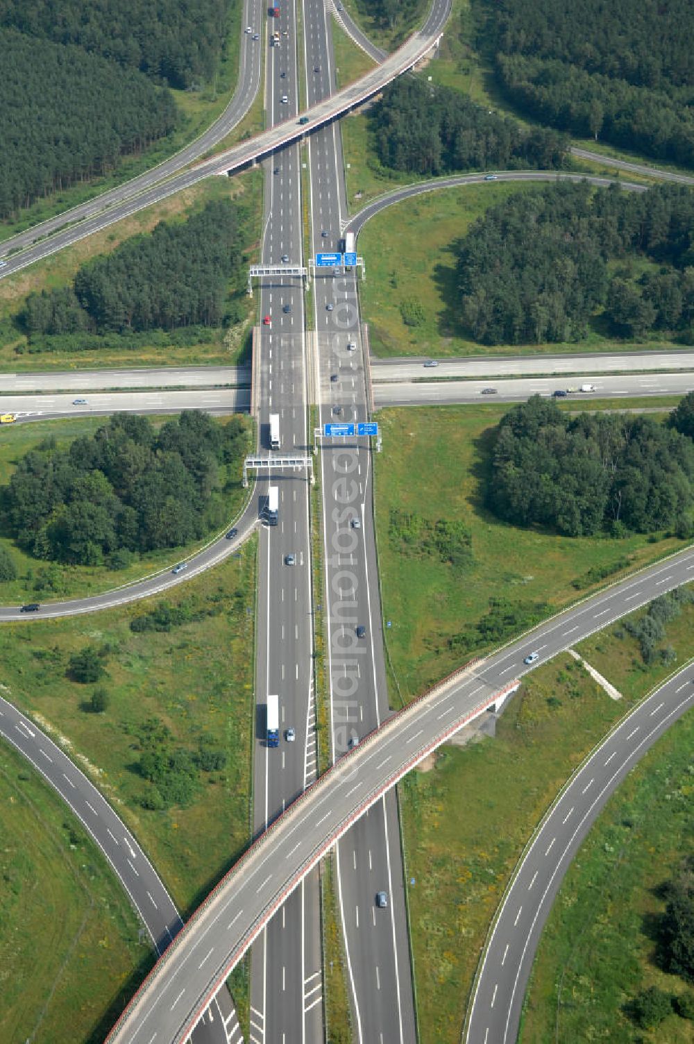 Aerial photograph Schönefeld - Blick auf das Autobahnkreuz Schönefeld. Das Schönefelder Kreuz (umgangssprachlich auch Kreuz Schönefeld) ist ein Autobahnkreuz am südlichen Berliner Ring (A 10), der nach Süden die A 13 Dresden und nach Norden die A 113 Berlin anbindet. Das Kreuz wurde ursprünglich in der verbreiteten Kleeblattform errichtet, wobei drei sehr enge Kreisel (Tempo: 20 bis 40 km/h) gesetzt wurden, bis zur Wende fehlte sogar eine Tangente (Durchfahren von drei Kreiseln notwendig). Lediglich der Kreisel im nordwestlichen Quadranten des Autobahnkreuzes wurde überdimensioniert - in Relation zum gesamten Autobahnkreuz - errichtet. Der Umbau des Schönefelder Kreuzes in den 1990ern brachte eine Mischform hervor, die in Richtung eines Malteserkreuzes geht, der Wechsel Nord nach Ost und Süd nach West hat jedoch weiterhin enge Kreisel.