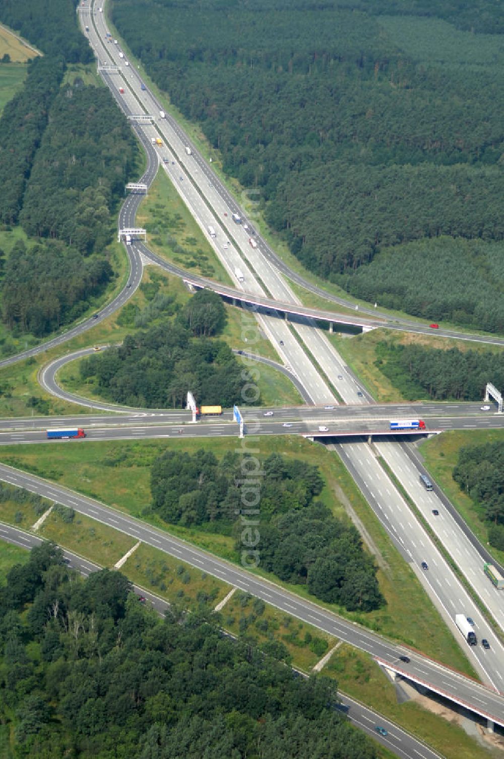 Schönefeld from above - Blick auf das Autobahnkreuz Schönefeld. Das Schönefelder Kreuz (umgangssprachlich auch Kreuz Schönefeld) ist ein Autobahnkreuz am südlichen Berliner Ring (A 10), der nach Süden die A 13 Dresden und nach Norden die A 113 Berlin anbindet. Das Kreuz wurde ursprünglich in der verbreiteten Kleeblattform errichtet, wobei drei sehr enge Kreisel (Tempo: 20 bis 40 km/h) gesetzt wurden, bis zur Wende fehlte sogar eine Tangente (Durchfahren von drei Kreiseln notwendig). Lediglich der Kreisel im nordwestlichen Quadranten des Autobahnkreuzes wurde überdimensioniert - in Relation zum gesamten Autobahnkreuz - errichtet. Der Umbau des Schönefelder Kreuzes in den 1990ern brachte eine Mischform hervor, die in Richtung eines Malteserkreuzes geht, der Wechsel Nord nach Ost und Süd nach West hat jedoch weiterhin enge Kreisel.