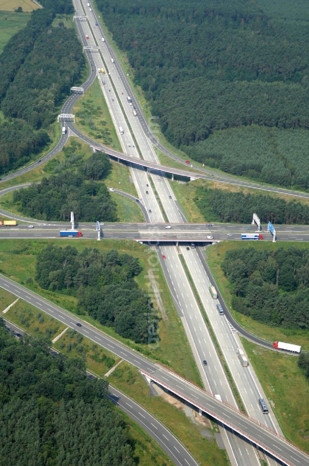 Schönefeld from the bird's eye view: Blick auf das Autobahnkreuz Schönefeld. Das Schönefelder Kreuz (umgangssprachlich auch Kreuz Schönefeld) ist ein Autobahnkreuz am südlichen Berliner Ring (A 10), der nach Süden die A 13 Dresden und nach Norden die A 113 Berlin anbindet. Das Kreuz wurde ursprünglich in der verbreiteten Kleeblattform errichtet, wobei drei sehr enge Kreisel (Tempo: 20 bis 40 km/h) gesetzt wurden, bis zur Wende fehlte sogar eine Tangente (Durchfahren von drei Kreiseln notwendig). Lediglich der Kreisel im nordwestlichen Quadranten des Autobahnkreuzes wurde überdimensioniert - in Relation zum gesamten Autobahnkreuz - errichtet. Der Umbau des Schönefelder Kreuzes in den 1990ern brachte eine Mischform hervor, die in Richtung eines Malteserkreuzes geht, der Wechsel Nord nach Ost und Süd nach West hat jedoch weiterhin enge Kreisel.