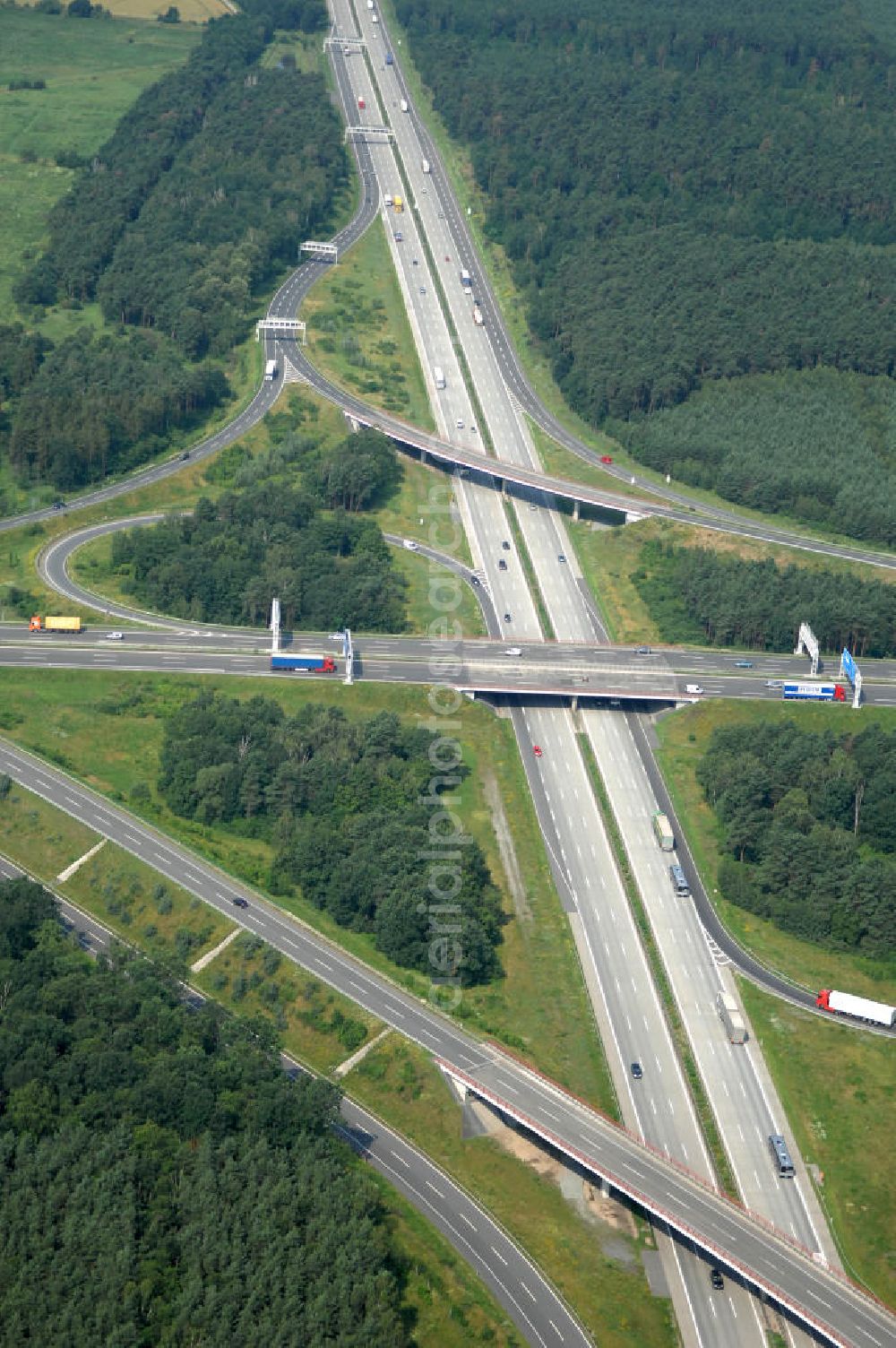 Aerial image Schönefeld - Blick auf das Autobahnkreuz Schönefeld. Das Schönefelder Kreuz (umgangssprachlich auch Kreuz Schönefeld) ist ein Autobahnkreuz am südlichen Berliner Ring (A 10), der nach Süden die A 13 Dresden und nach Norden die A 113 Berlin anbindet. Das Kreuz wurde ursprünglich in der verbreiteten Kleeblattform errichtet, wobei drei sehr enge Kreisel (Tempo: 20 bis 40 km/h) gesetzt wurden, bis zur Wende fehlte sogar eine Tangente (Durchfahren von drei Kreiseln notwendig). Lediglich der Kreisel im nordwestlichen Quadranten des Autobahnkreuzes wurde überdimensioniert - in Relation zum gesamten Autobahnkreuz - errichtet. Der Umbau des Schönefelder Kreuzes in den 1990ern brachte eine Mischform hervor, die in Richtung eines Malteserkreuzes geht, der Wechsel Nord nach Ost und Süd nach West hat jedoch weiterhin enge Kreisel.