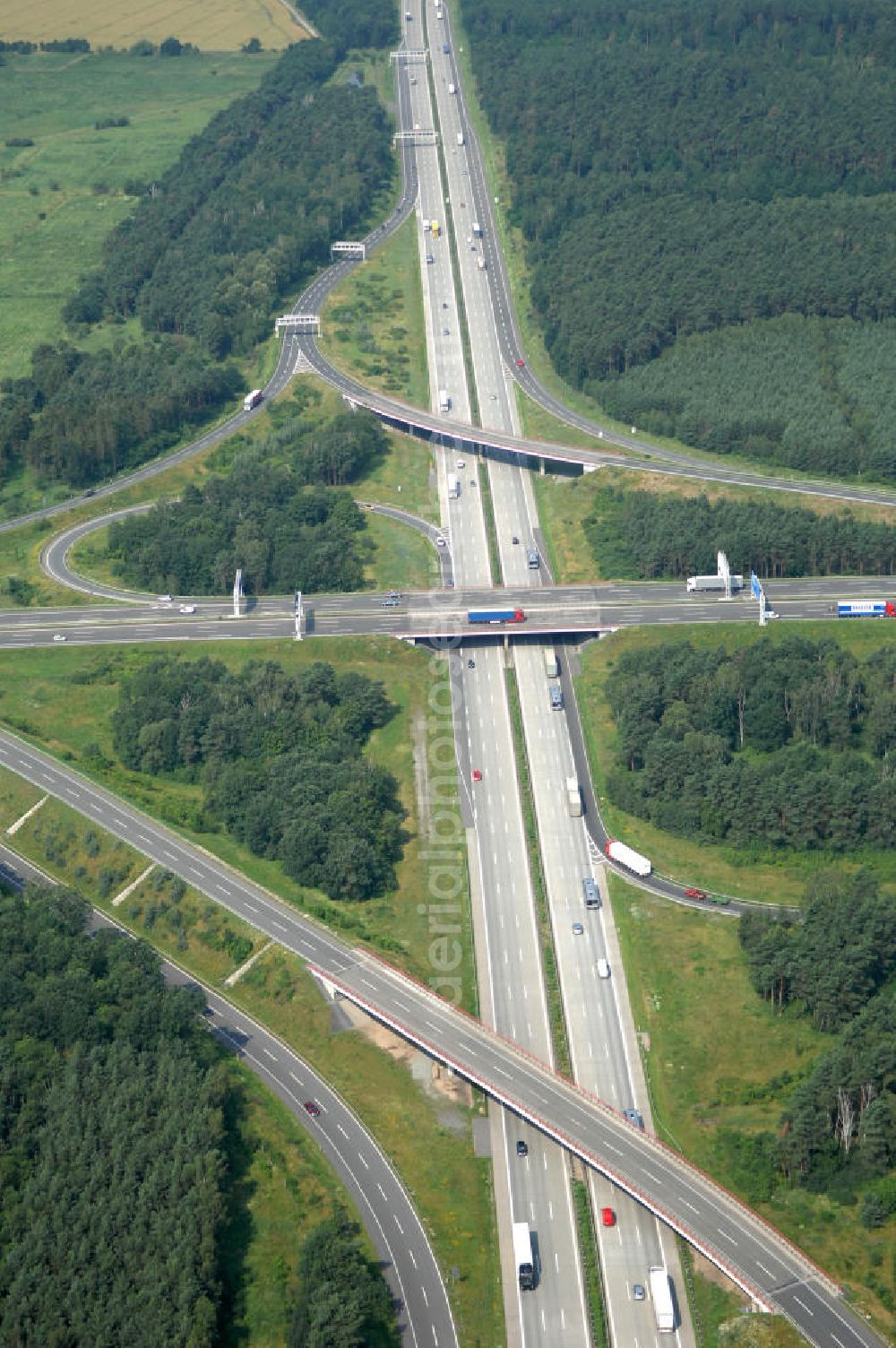 Schönefeld from above - Blick auf das Autobahnkreuz Schönefeld. Das Schönefelder Kreuz (umgangssprachlich auch Kreuz Schönefeld) ist ein Autobahnkreuz am südlichen Berliner Ring (A 10), der nach Süden die A 13 Dresden und nach Norden die A 113 Berlin anbindet. Das Kreuz wurde ursprünglich in der verbreiteten Kleeblattform errichtet, wobei drei sehr enge Kreisel (Tempo: 20 bis 40 km/h) gesetzt wurden, bis zur Wende fehlte sogar eine Tangente (Durchfahren von drei Kreiseln notwendig). Lediglich der Kreisel im nordwestlichen Quadranten des Autobahnkreuzes wurde überdimensioniert - in Relation zum gesamten Autobahnkreuz - errichtet. Der Umbau des Schönefelder Kreuzes in den 1990ern brachte eine Mischform hervor, die in Richtung eines Malteserkreuzes geht, der Wechsel Nord nach Ost und Süd nach West hat jedoch weiterhin enge Kreisel.