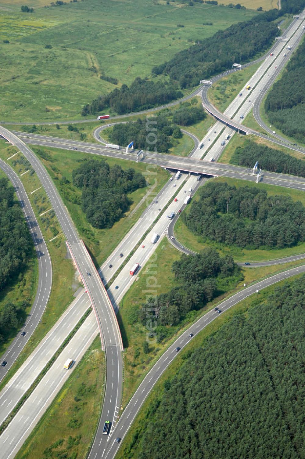 Aerial image Schönefeld - Blick auf das Autobahnkreuz Schönefeld. Das Schönefelder Kreuz (umgangssprachlich auch Kreuz Schönefeld) ist ein Autobahnkreuz am südlichen Berliner Ring (A 10), der nach Süden die A 13 Dresden und nach Norden die A 113 Berlin anbindet. Das Kreuz wurde ursprünglich in der verbreiteten Kleeblattform errichtet, wobei drei sehr enge Kreisel (Tempo: 20 bis 40 km/h) gesetzt wurden, bis zur Wende fehlte sogar eine Tangente (Durchfahren von drei Kreiseln notwendig). Lediglich der Kreisel im nordwestlichen Quadranten des Autobahnkreuzes wurde überdimensioniert - in Relation zum gesamten Autobahnkreuz - errichtet. Der Umbau des Schönefelder Kreuzes in den 1990ern brachte eine Mischform hervor, die in Richtung eines Malteserkreuzes geht, der Wechsel Nord nach Ost und Süd nach West hat jedoch weiterhin enge Kreisel.