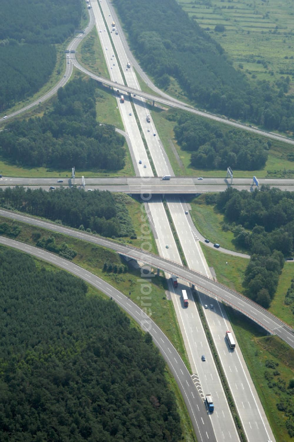 Aerial photograph Schönefeld - Blick auf das Autobahnkreuz Schönefeld. Das Schönefelder Kreuz (umgangssprachlich auch Kreuz Schönefeld) ist ein Autobahnkreuz am südlichen Berliner Ring (A 10), der nach Süden die A 13 Dresden und nach Norden die A 113 Berlin anbindet. Das Kreuz wurde ursprünglich in der verbreiteten Kleeblattform errichtet, wobei drei sehr enge Kreisel (Tempo: 20 bis 40 km/h) gesetzt wurden, bis zur Wende fehlte sogar eine Tangente (Durchfahren von drei Kreiseln notwendig). Lediglich der Kreisel im nordwestlichen Quadranten des Autobahnkreuzes wurde überdimensioniert - in Relation zum gesamten Autobahnkreuz - errichtet. Der Umbau des Schönefelder Kreuzes in den 1990ern brachte eine Mischform hervor, die in Richtung eines Malteserkreuzes geht, der Wechsel Nord nach Ost und Süd nach West hat jedoch weiterhin enge Kreisel.