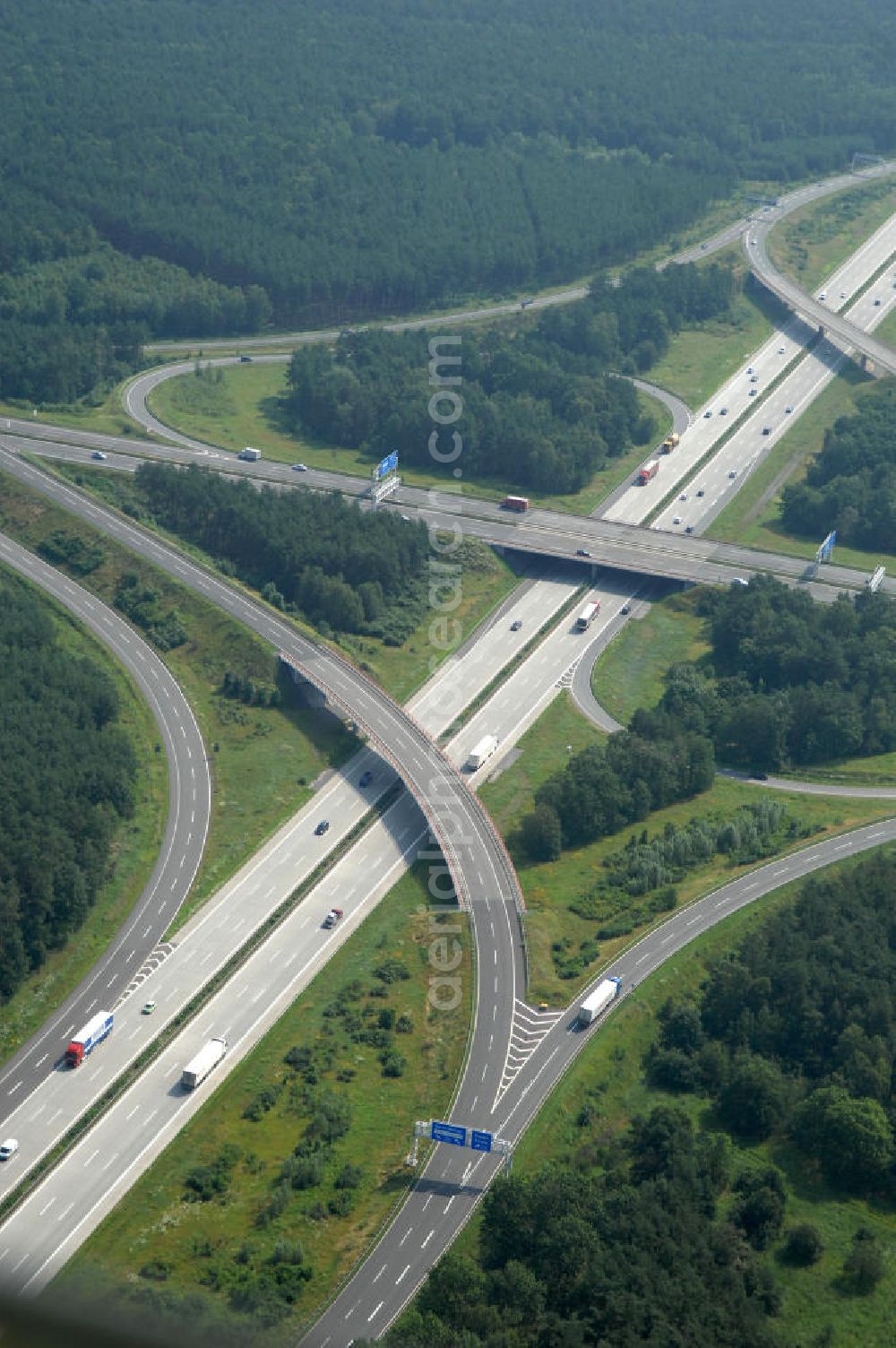 Aerial image Schönefeld - Blick auf das Autobahnkreuz Schönefeld. Das Schönefelder Kreuz (umgangssprachlich auch Kreuz Schönefeld) ist ein Autobahnkreuz am südlichen Berliner Ring (A 10), der nach Süden die A 13 Dresden und nach Norden die A 113 Berlin anbindet. Das Kreuz wurde ursprünglich in der verbreiteten Kleeblattform errichtet, wobei drei sehr enge Kreisel (Tempo: 20 bis 40 km/h) gesetzt wurden, bis zur Wende fehlte sogar eine Tangente (Durchfahren von drei Kreiseln notwendig). Lediglich der Kreisel im nordwestlichen Quadranten des Autobahnkreuzes wurde überdimensioniert - in Relation zum gesamten Autobahnkreuz - errichtet. Der Umbau des Schönefelder Kreuzes in den 1990ern brachte eine Mischform hervor, die in Richtung eines Malteserkreuzes geht, der Wechsel Nord nach Ost und Süd nach West hat jedoch weiterhin enge Kreisel.