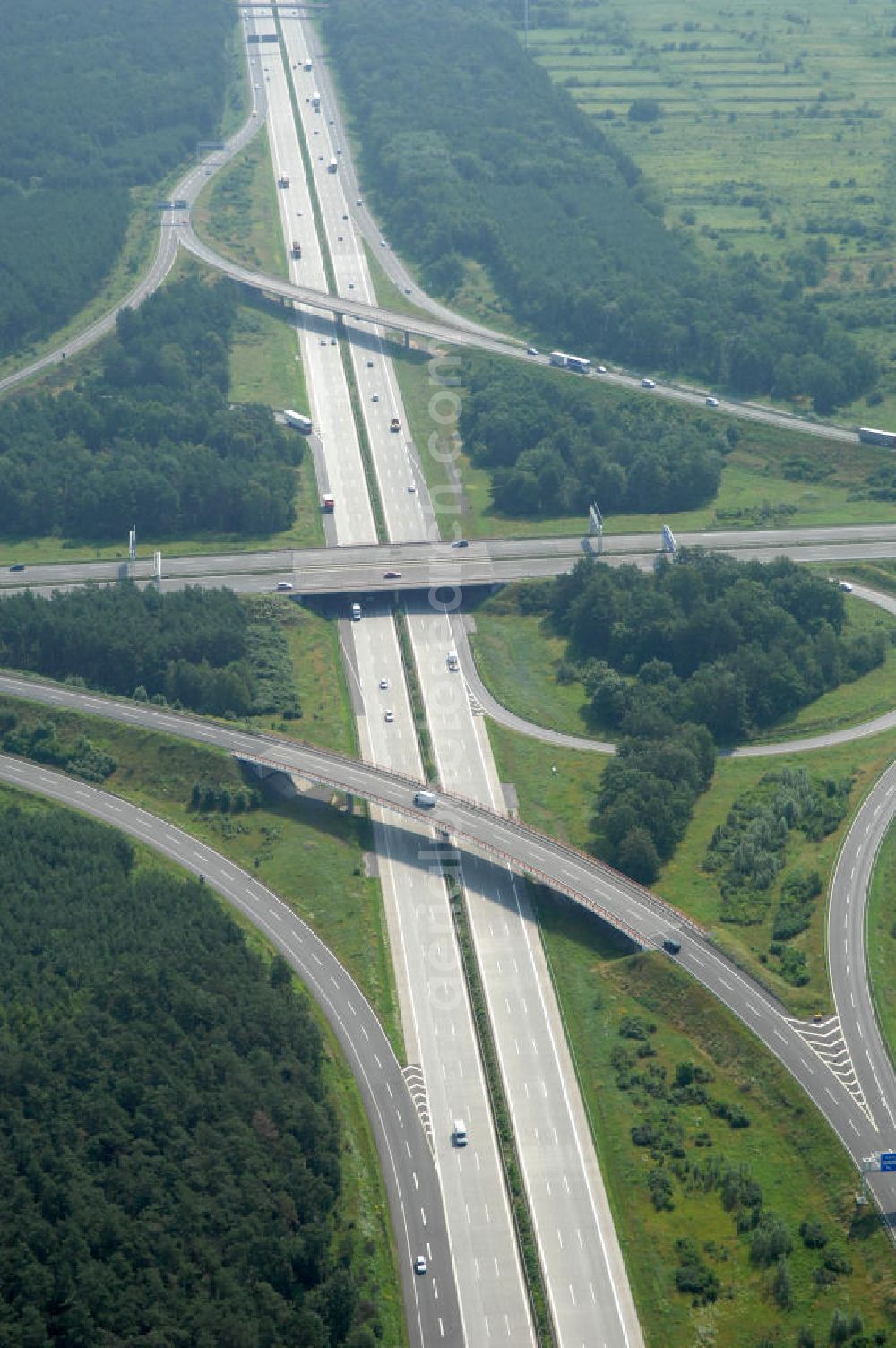 Aerial photograph Schönefeld - Blick auf das Autobahnkreuz Schönefeld. Das Schönefelder Kreuz (umgangssprachlich auch Kreuz Schönefeld) ist ein Autobahnkreuz am südlichen Berliner Ring (A 10), der nach Süden die A 13 Dresden und nach Norden die A 113 Berlin anbindet. Das Kreuz wurde ursprünglich in der verbreiteten Kleeblattform errichtet, wobei drei sehr enge Kreisel (Tempo: 20 bis 40 km/h) gesetzt wurden, bis zur Wende fehlte sogar eine Tangente (Durchfahren von drei Kreiseln notwendig). Lediglich der Kreisel im nordwestlichen Quadranten des Autobahnkreuzes wurde überdimensioniert - in Relation zum gesamten Autobahnkreuz - errichtet. Der Umbau des Schönefelder Kreuzes in den 1990ern brachte eine Mischform hervor, die in Richtung eines Malteserkreuzes geht, der Wechsel Nord nach Ost und Süd nach West hat jedoch weiterhin enge Kreisel.