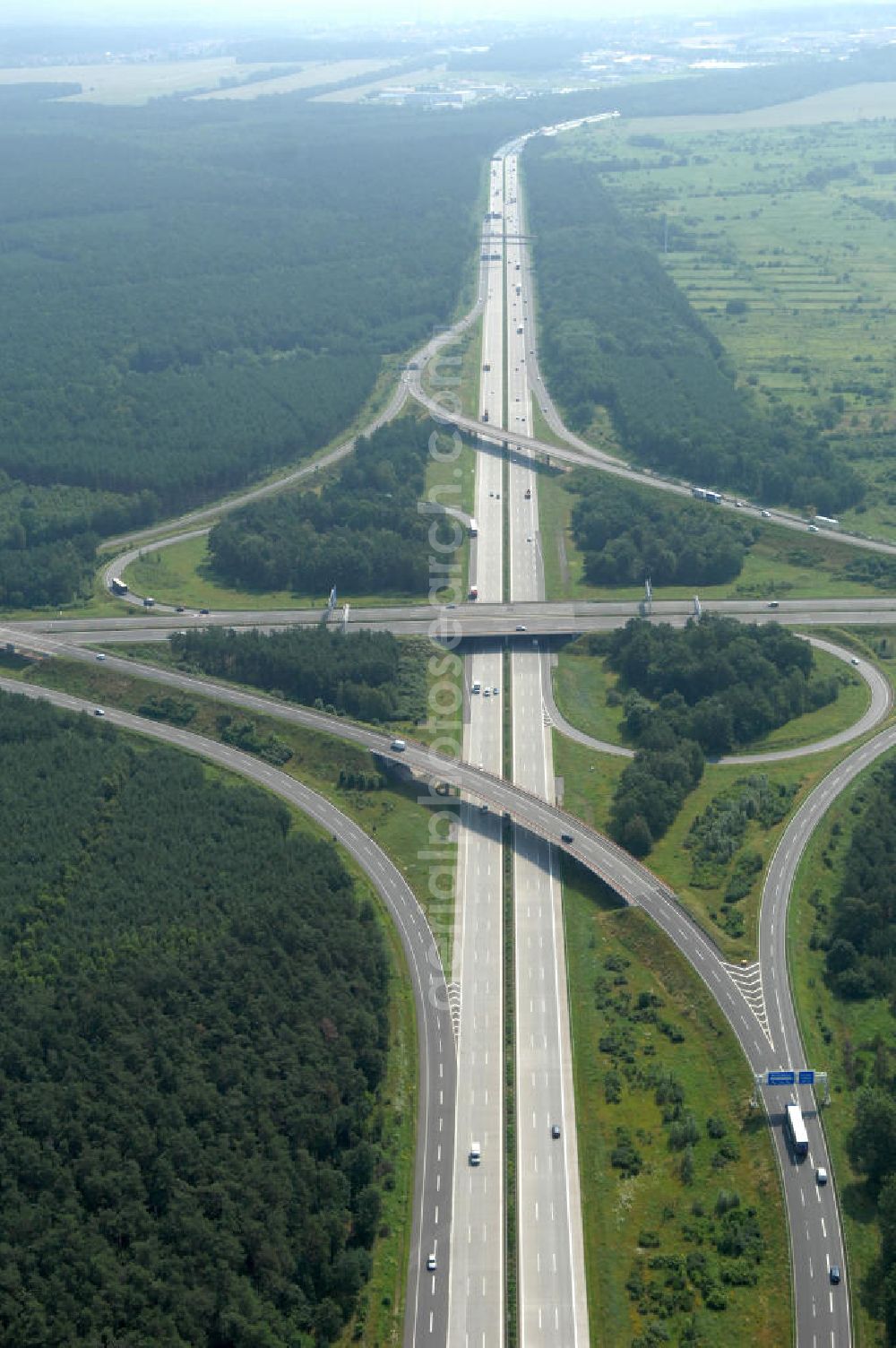 Schönefeld from above - Blick auf das Autobahnkreuz Schönefeld. Das Schönefelder Kreuz (umgangssprachlich auch Kreuz Schönefeld) ist ein Autobahnkreuz am südlichen Berliner Ring (A 10), der nach Süden die A 13 Dresden und nach Norden die A 113 Berlin anbindet. Das Kreuz wurde ursprünglich in der verbreiteten Kleeblattform errichtet, wobei drei sehr enge Kreisel (Tempo: 20 bis 40 km/h) gesetzt wurden, bis zur Wende fehlte sogar eine Tangente (Durchfahren von drei Kreiseln notwendig). Lediglich der Kreisel im nordwestlichen Quadranten des Autobahnkreuzes wurde überdimensioniert - in Relation zum gesamten Autobahnkreuz - errichtet. Der Umbau des Schönefelder Kreuzes in den 1990ern brachte eine Mischform hervor, die in Richtung eines Malteserkreuzes geht, der Wechsel Nord nach Ost und Süd nach West hat jedoch weiterhin enge Kreisel.