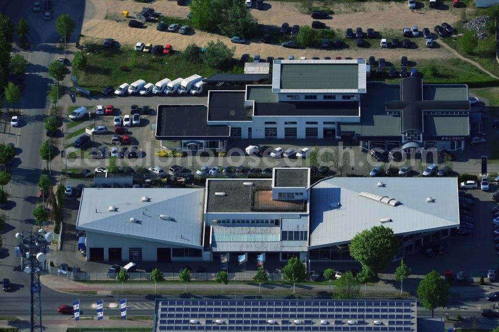 Aerial photograph Teltow - In the commercial district of Teltow Oderstrasse in Teltow in Brandenburg the car dealer Brit Cars - Riller & Schnauck GmbH has a subsidiary. Here new and used cars from Jaguar and Rover are offered at a service center car repairs are made. The underlying building cars Peugeot sold and serviced