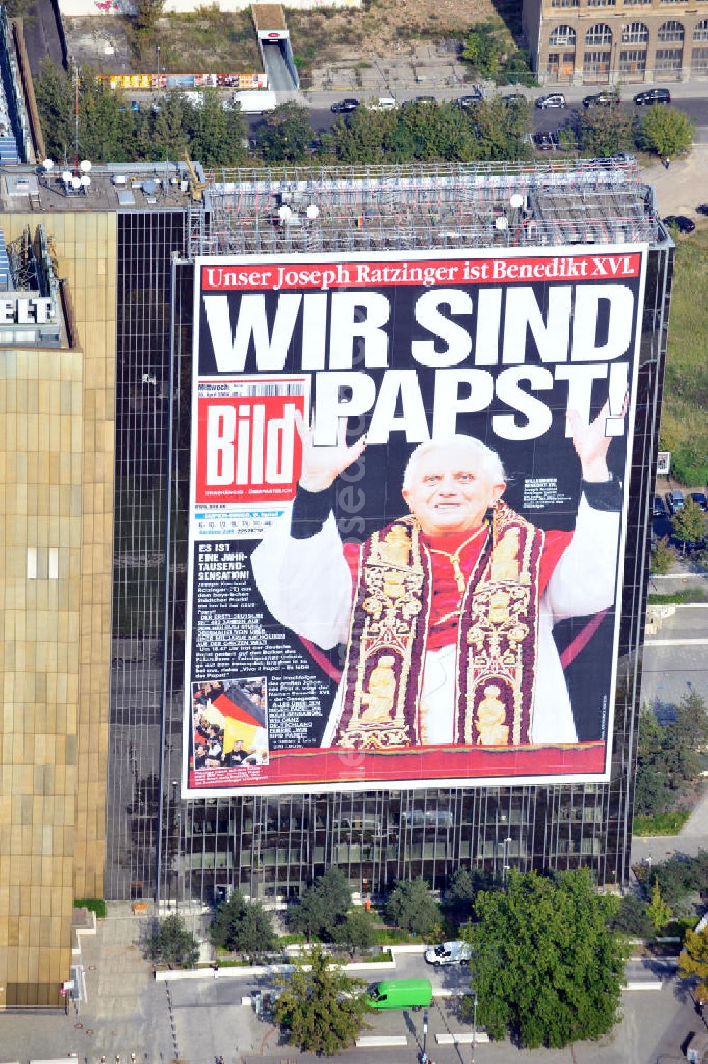 Berlin Kreuzberg from the bird's eye view: Verlagsgebäude Axel-Springer-Haus geschmückt mit der Tietelseite der Bildzeitung vom Tag nach der Wahl von Joseph Ratzinger zum Papst Benedikt XVI in Berlin-Kreuzberg. Publisher building Axel-Springer-Haus decorated with the cover of the newspaper Bild from the day after the election of Joseph Ratzinger to Pope Benedict XVI in Berlin-Kreuzberg.