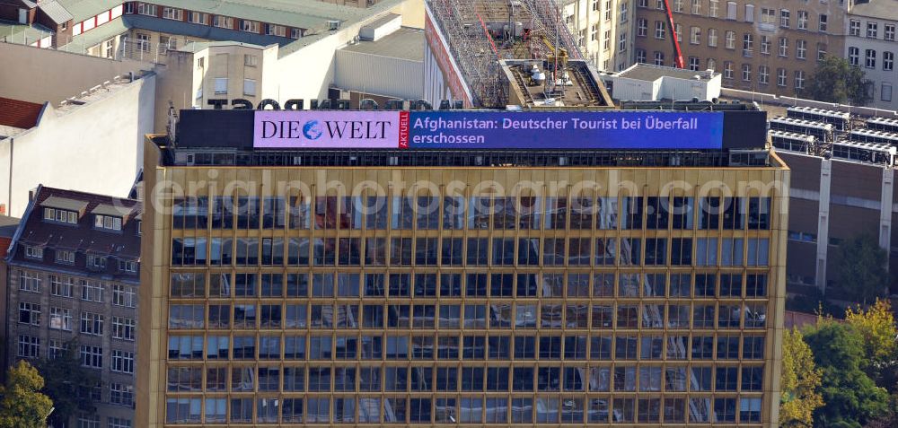 Aerial photograph Berlin - Auf dem Dach des Axel Springer Verlagsgebäudes in Berlin Kreuzberg werden die Zeitungen des Verlages beworben. Unter Anderem werden dort Schlagzeilen aus Die Welt auf einem LCD Bildschirm angezeigt. On the roof of Axel Springer publishing house in the district of Kreuzberg you can find commercials for its newspapers. Headlines of Die Welt are published on an LCD display.