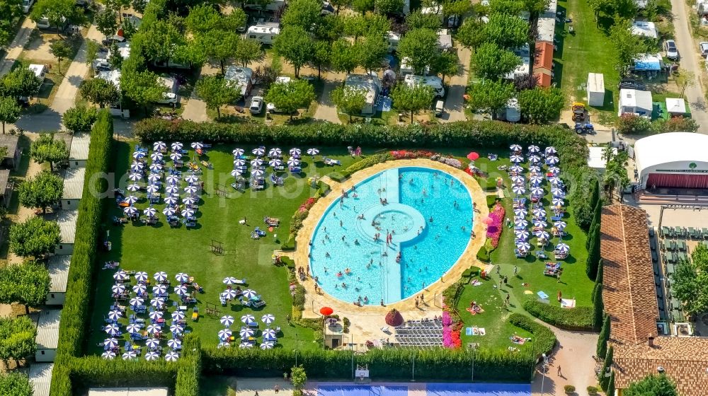 Lazise from the bird's eye view: Bathers on the lawn by the pool of the campsite La Quercia in Lazise in Veneto, Italy