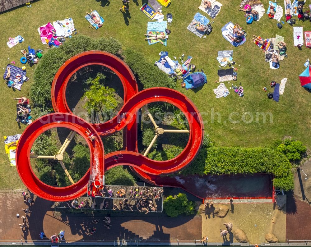 Mülheim an der Ruhr from above - Bathers on the circular round red water slides on the lawn by the pool of the swimming pool - natural bath Muelheim-Styrum in Muelheim an der Ruhr in North Rhine-Westphalia