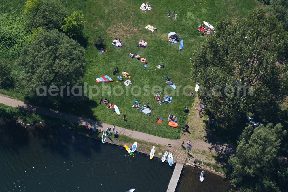 Bremen from the bird's eye view: Bathers and water sports enthusiasts with SUB board on the sunbathing lawn and on the shore of the Stadtwaldsee in Bremen, Germany