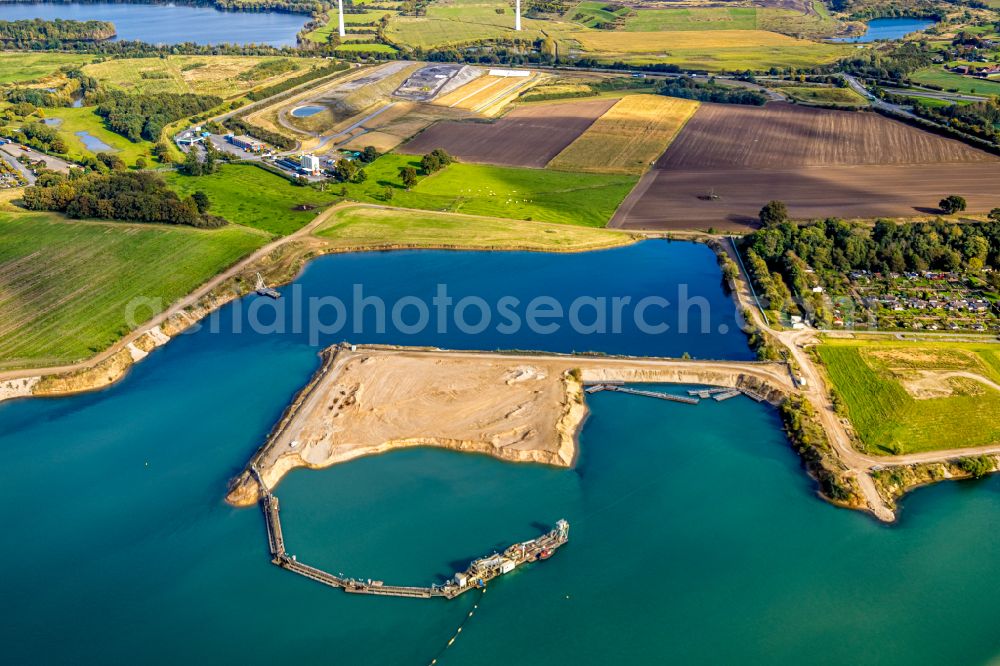 Aerial image Kamp-Lintfort - Lake shore and overburden areas of the quarry lake and gravel open pit of Heidelberger Sand and Kies GmbH in Kamp-Lintfort at Ruhrgebiet in the state North Rhine-Westphalia, Germany