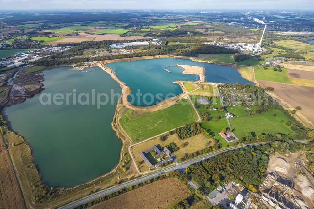 Kamp-Lintfort from the bird's eye view: Lake shore and overburden areas of the quarry lake and gravel open pit of Heidelberger Sand and Kies GmbH in Kamp-Lintfort at Ruhrgebiet in the state North Rhine-Westphalia, Germany