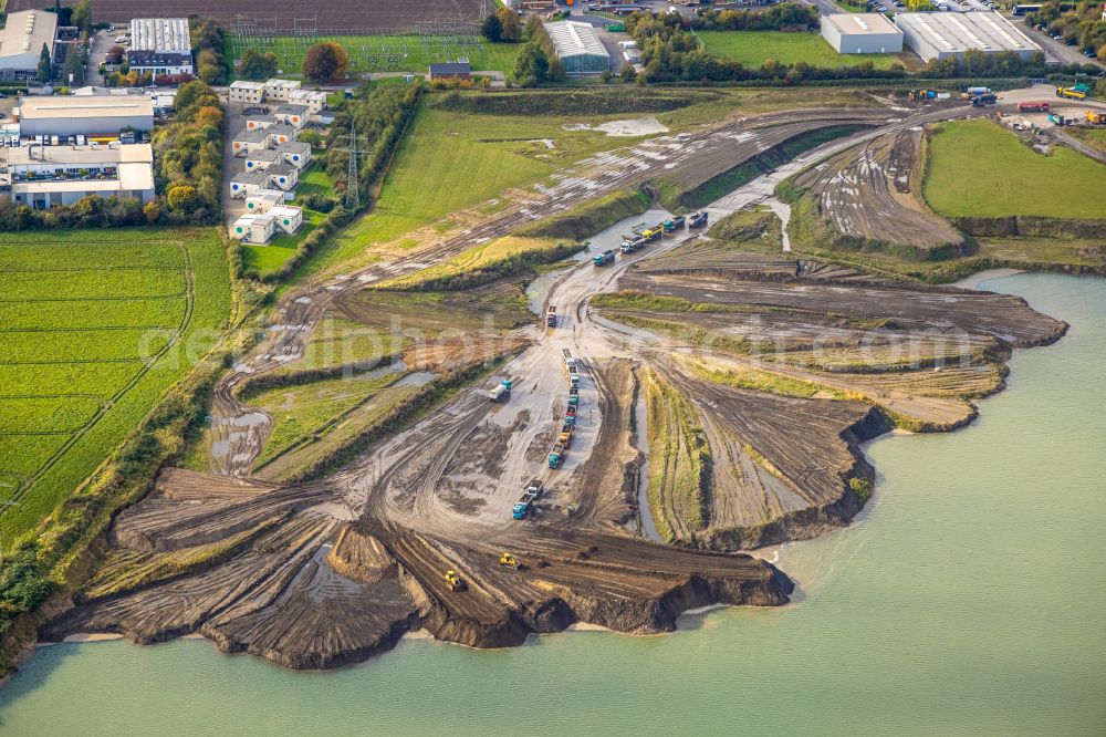 Aerial image Kamp-Lintfort - Lake shore and overburden areas of the quarry lake and gravel open pit of Heidelberger Sand and Kies GmbH in Kamp-Lintfort at Ruhrgebiet in the state North Rhine-Westphalia, Germany