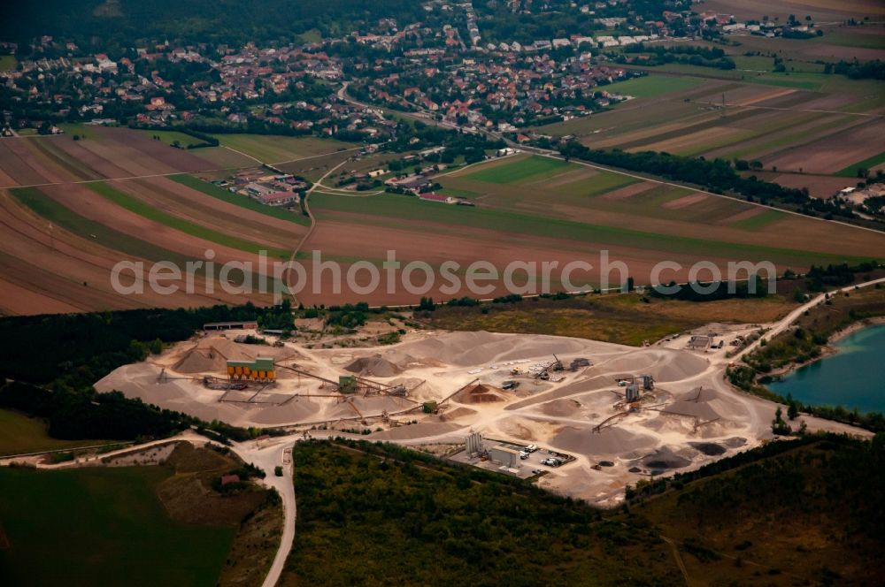 Brunn an der Schneebergbahn from the bird's eye view: Lake shore and overburden areas of the quarry lake and gravel open pit ROHRDORFER Kieswerk in Bad Fischau in Lower Austria, Austria