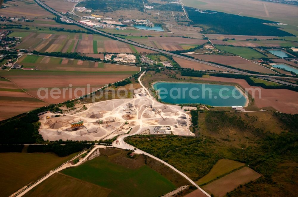 Aerial image Brunn an der Schneebergbahn - Lake shore and overburden areas of the quarry lake and gravel open pit ROHRDORFER Kieswerk in Bad Fischau in Lower Austria, Austria